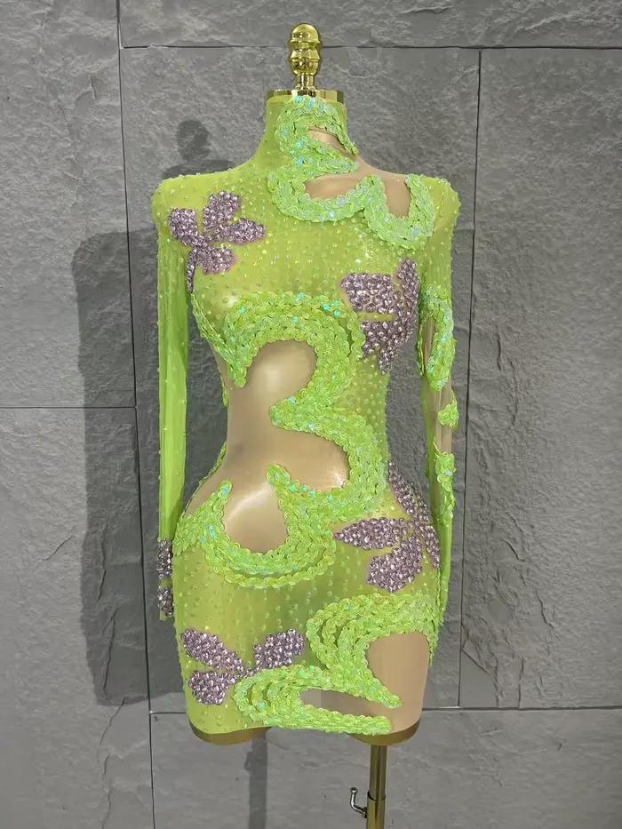 Mini-jupe verte décorée de paillettes, coupe transparente à manches longues qui s'adapte parfaitemen