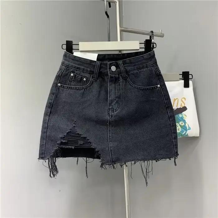 Jupes demi-corps en Denim irrégulier lavé et portées. Nouvelle mode d'été et jupe courte en Denim ta