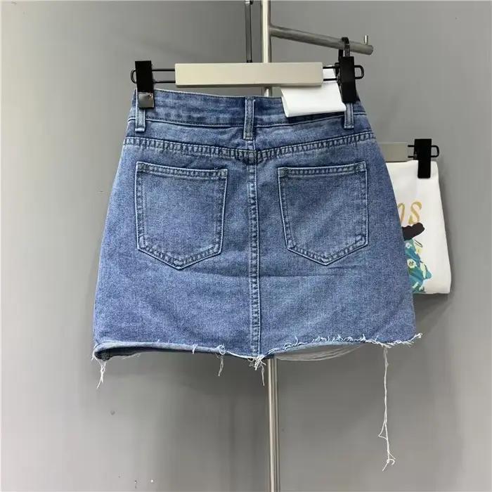 Jupes demi-corps en Denim irrégulier lavé et portées. Nouvelle mode d'été et jupe courte