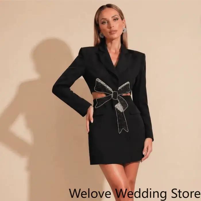 Mini-robe noire chic de style blazer à revers, manches longues, avec nœud en strass étincelant